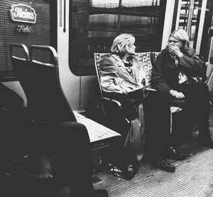 Woman covers her mouth in shock on the T train